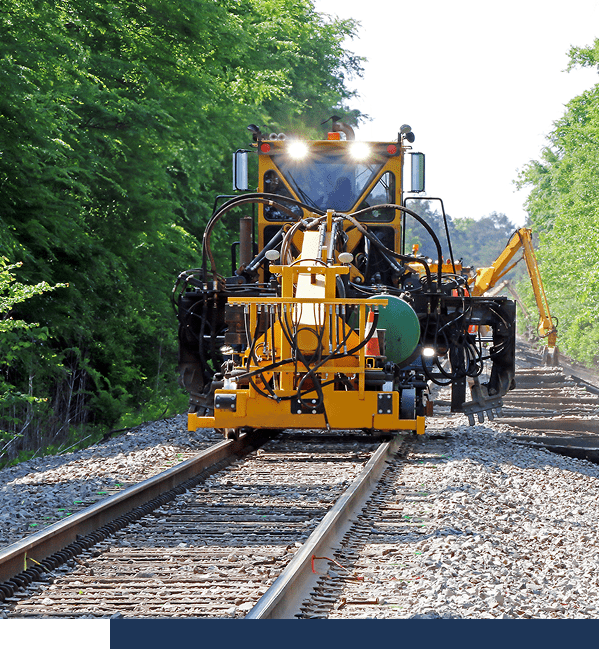 Yellow machine working on railway tracks.