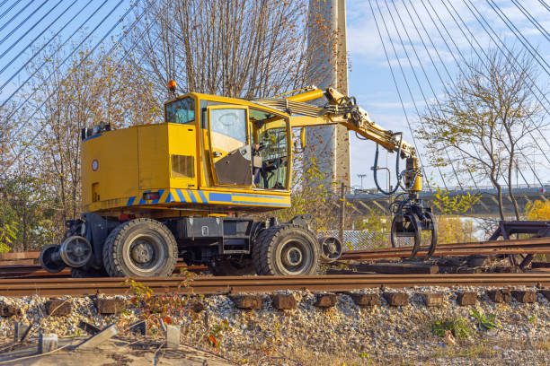 Yellow machine working on railroad tracks.