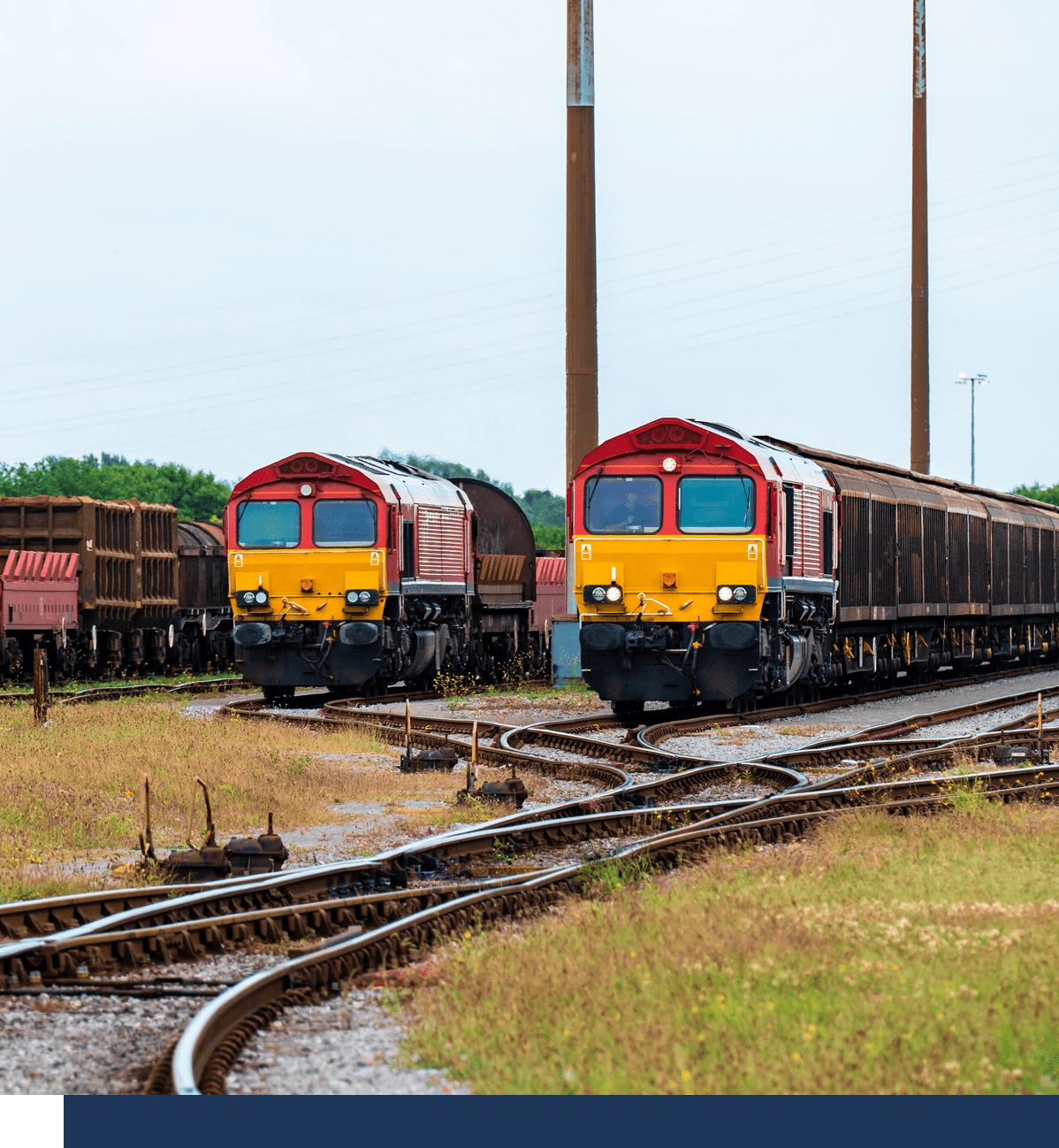Two red trains on railway tracks.